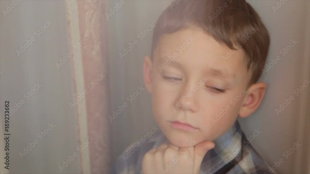 A sad child looks out the window A sad child looks out the window