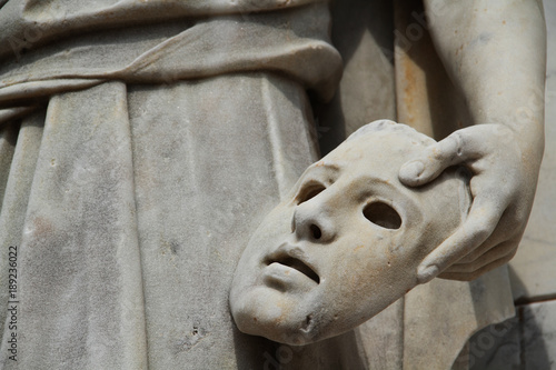 Photography Marble stone sculpted statue holding a dramatic mask and found in a public park