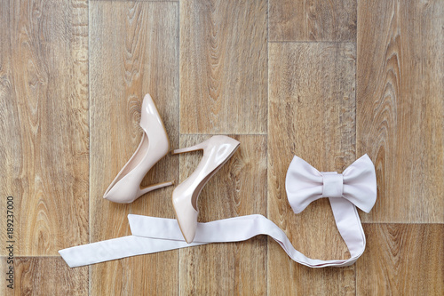 The bride's shoes and dress belt lie on the beautiful floor