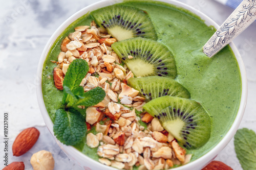 Green smoothie bowl with nuts closeup.
