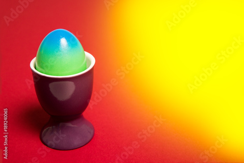 Colorfull easter egg on a yellowred background photo