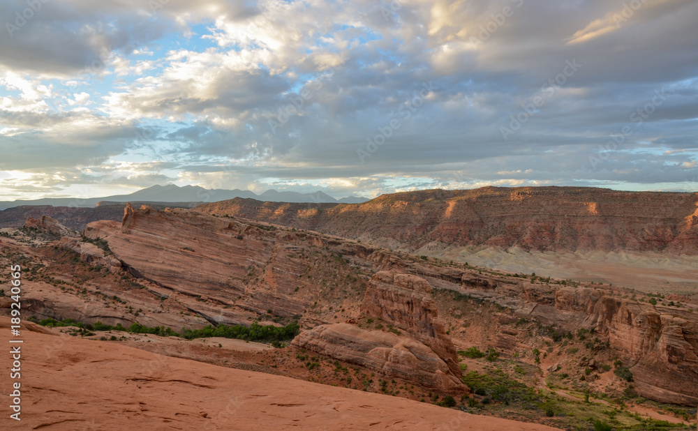 blue sky and clouds over cliffs of Salt Valley at sunrise panoramic view from Delicate Arch
Arches National Park, Moab, Utah