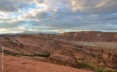 blue sky and clouds over cliffs of Salt Valley at sunrise panoramic view from Delicate Arch  Arches National Park, Moab, Utah © ssmalomuzh