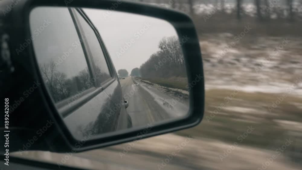 Back road reflected in car mirror, car driving fast. Back road reflected in car mirror, car driving fast.
