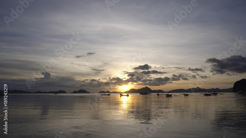Marine tropical sunset over the sea. Sunset over the sea in the background boats, orange sky and islands. Travel concept. Nothing but sky, clouds and water. Beautiful serene scene.