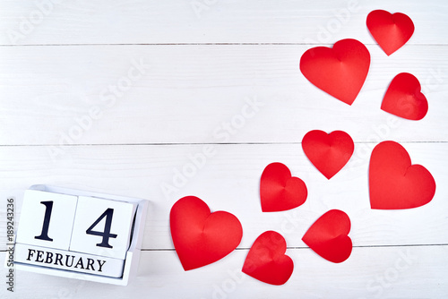 Valentines Day background with paper red hearts and wooden block calendar february 14, copy space. Greeting card mockup. Symbol of love. Love concept, Top view, flat lay