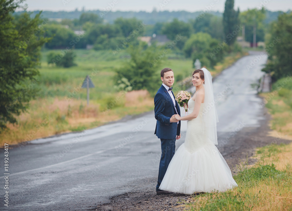 Elegant bride and groom posing together outdoors Elegant bride and groom posing together outdoors