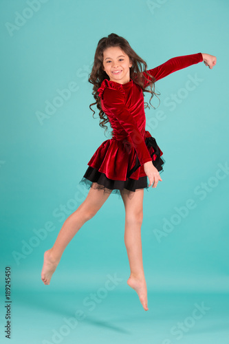 Little girl dancer jump on blue background