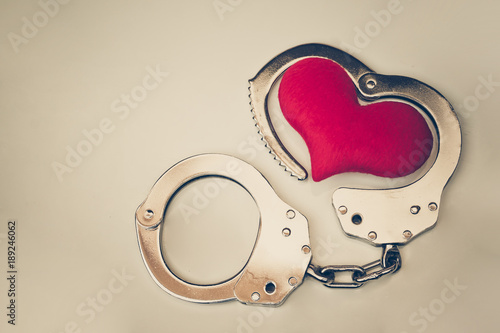 Картината върху платно Handcuffs with a red love heart with copy space to add text