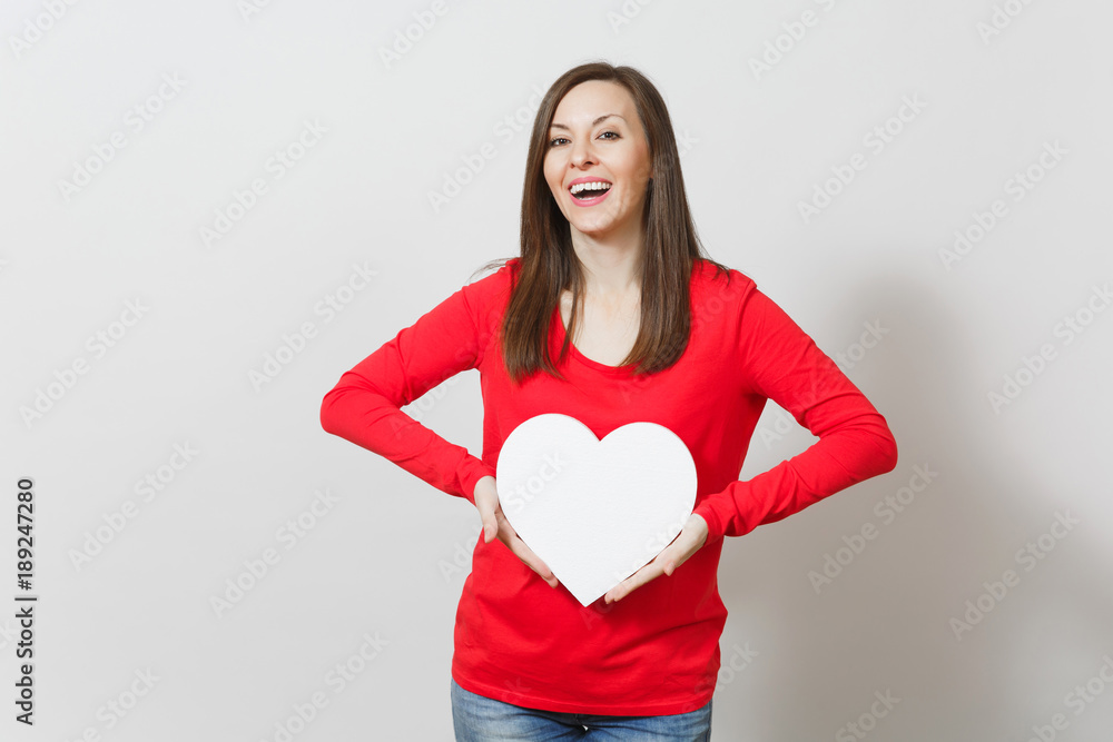 Pretty woman in red clothes holding big white heart in hands isolated on white background. Copy space for advertisement. With place for text. St. Valentine's Day or International Women's Day concept. Pretty woman in red clothes holding big white heart in hands isolated on white background. Copy space for advertisement. With place for text. St. Valentine's Day or International Women's Day concept.