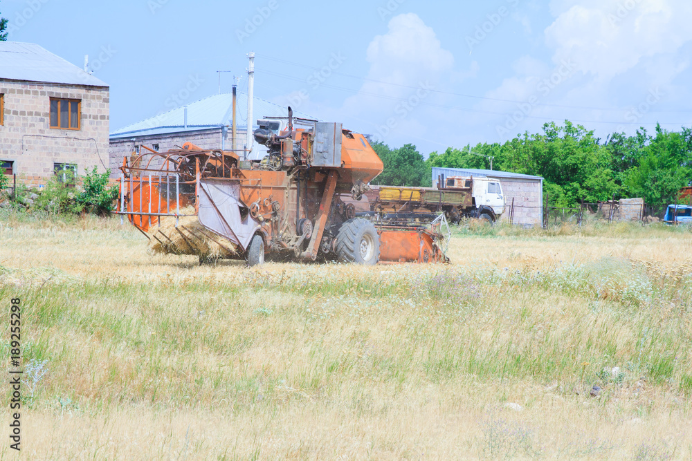 Fototapeta premium An old tractor working in a field