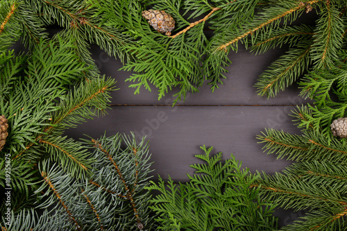 Christmas background  decor  attributes  on a wooden background. Set of fresh fir branches and ornaments of red and gold balls. Cones and bells.