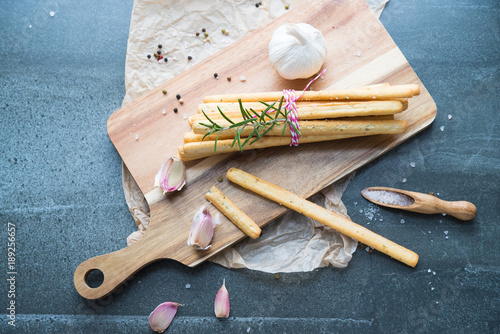 bread grissini with garlic and rosemary, sprinkled with salt on a stone table photo