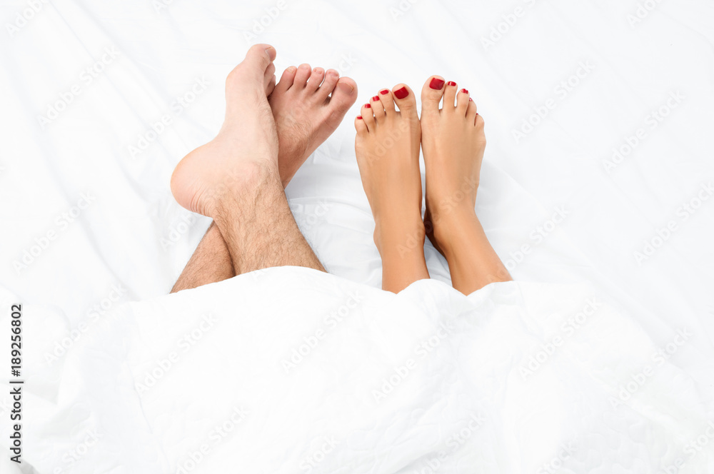 Close up of the feet of a couple on the bed. Close up of the feet of a couple on the bed.