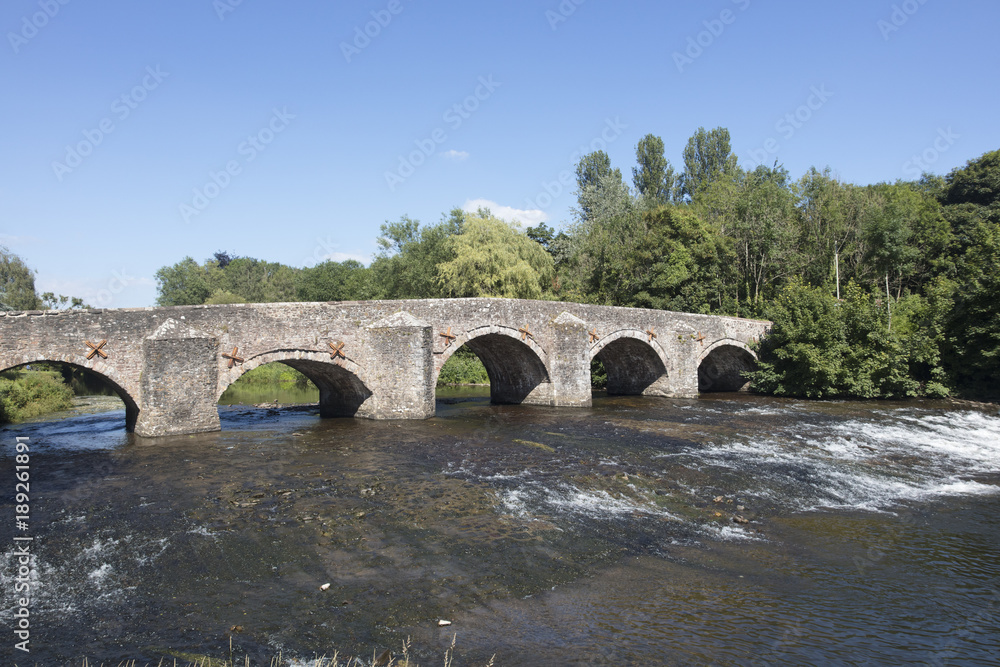 The River Exe flows under the medieval stone bridge at Bickley Devon England