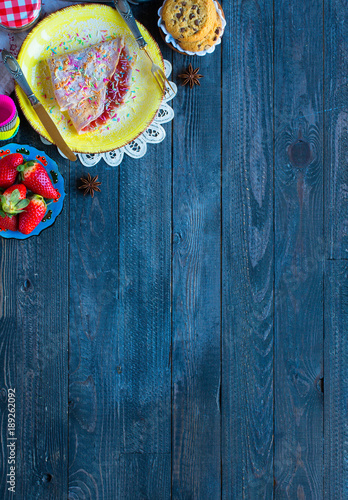 Fresh homemade crepes served on a plate with strawberries and blueberries, on a dark wooden background,