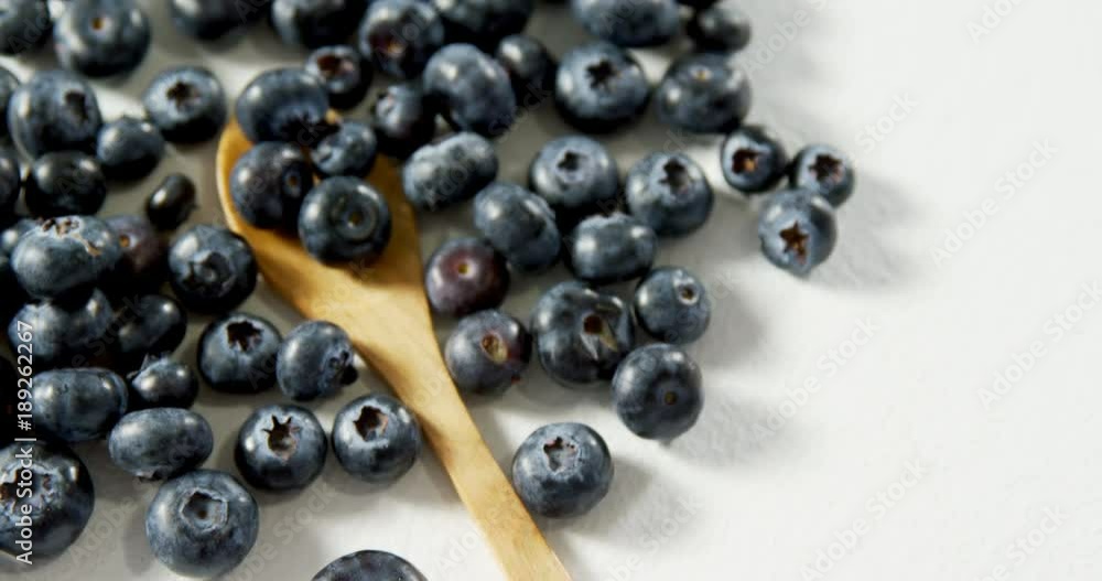 Blueberries with wooden spoon on white background  