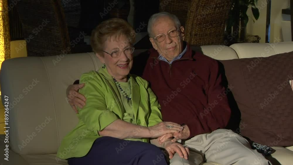 Affectionate elderly couple watching TV Wide Affectionate elderly couple watching TV Wide