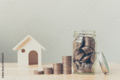 Property investment and house mortgage financial concept, Money coin stack with wooden house photo