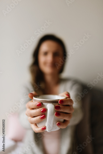 Unrecognizable woman holding a cup of coffee.