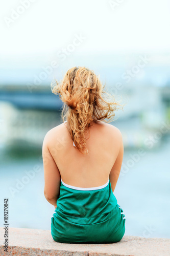 young pretty sexy girl sitting on the parapet back view © Sergey