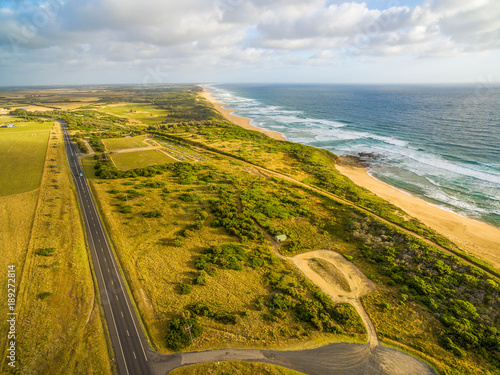 Aerial view of ocean coastline and straight rural highway in Australia photo