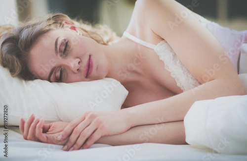 Pretty woman lying down on her bed at home.