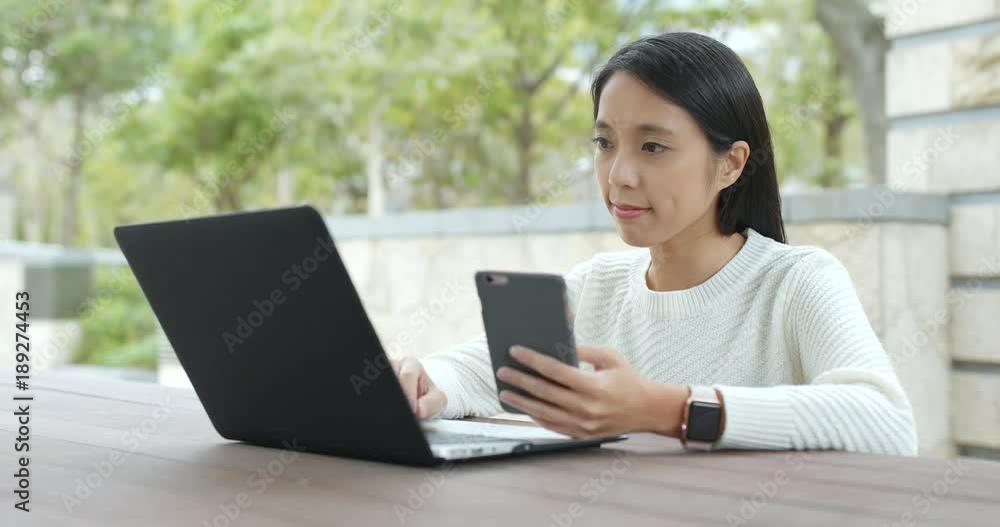 Woman working on notebook computer and using of cellphone Woman working on notebook computer and using of cellphone