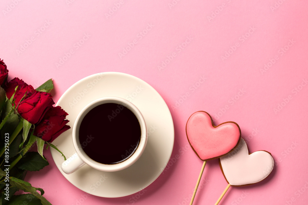 Gingerbread hearts, red roses and a cup of coffee on a pink background. Gingerbread hearts, red roses and a cup of coffee on a pink background.