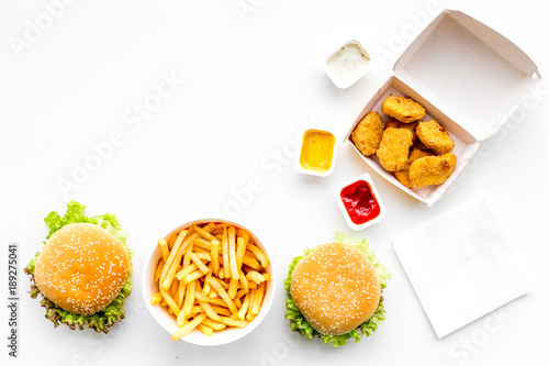 Fototapeta Naklejka Na Ścianę i Meble -  Fast food. Chiken nuggets, burgers and french fries on white background top view space for text