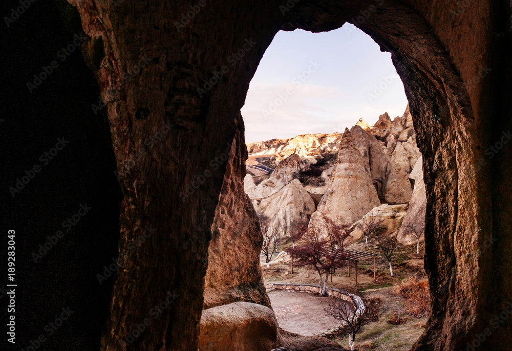 Nunnery inside volcanic rock landscape at Goreme Open air museum, Cappadocia, Turkey. Shot through cave