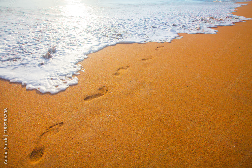 beach, wave and footprints at sunset time beach, wave and footprints at sunset time