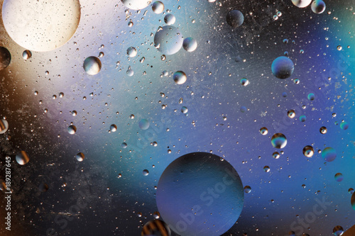 Oil bubbles in an aqueous medium on the border with a glass surface. Abstract Screen Saver.