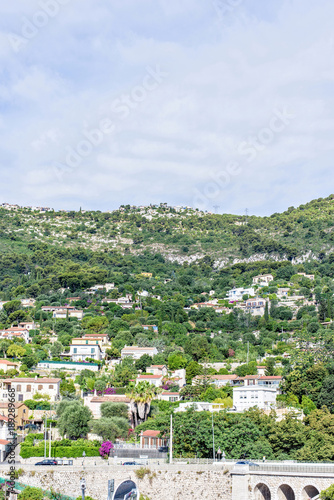 Daylight sunny view to city buildings and green trees on mountains