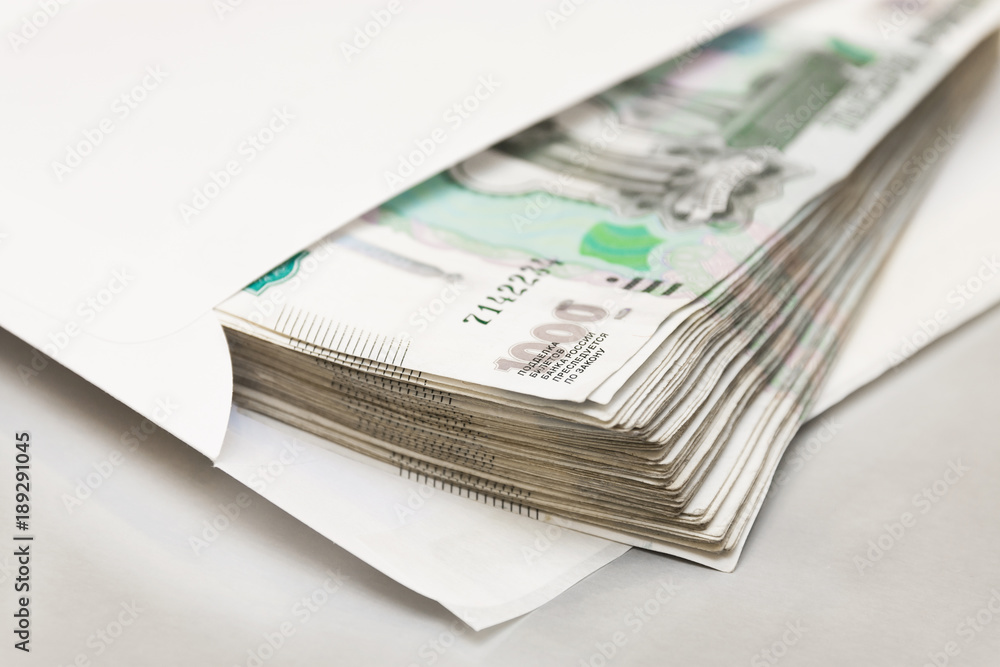 One thousandth bills in an envelope on a light background. The concept of a bribe. Selective focus One thousandth bills in an envelope on a light background. The concept of a bribe. Selective focus
