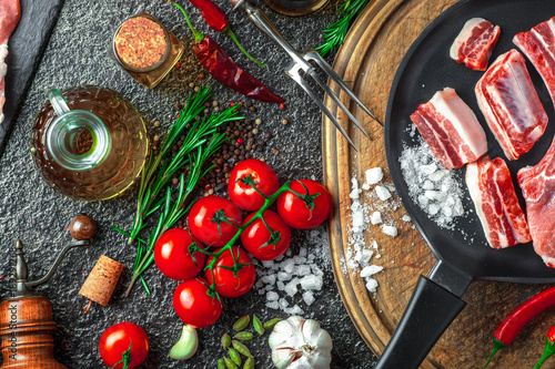 Raw meat on the kitchen table on a metallic background in a composition with cooking accessories