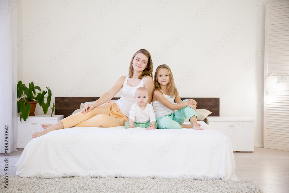 three girls play sisters in the morning on the bed in the bedroom three girls play sisters in the morning on the bed in the bedroom