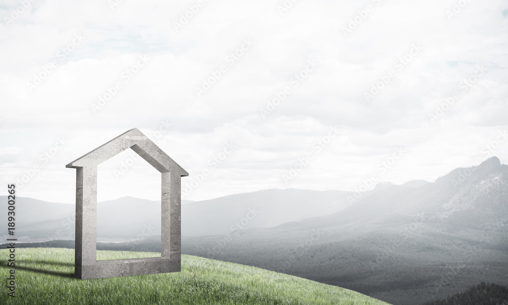 Conceptual image of concrete home sign on hill and natural lands Conceptual image of concrete home sign on hill and natural lands