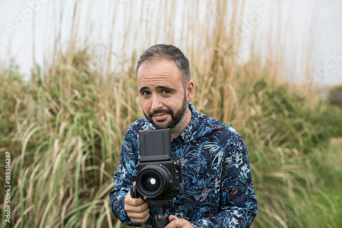 Cheerful adult man with camera