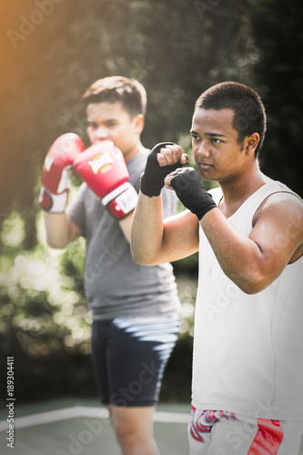Asian young men with personal trainer boxing friend, Boxing gloves © kasipat