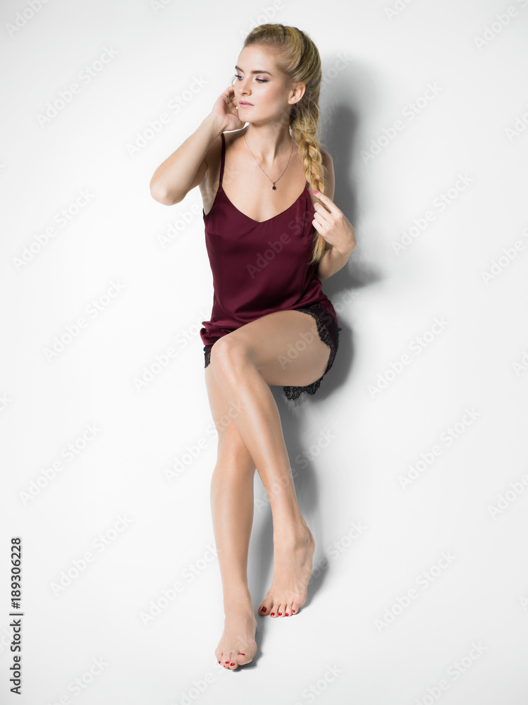 Fototapeta premium Blonde woman sitting on a white background