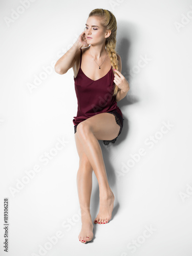 Blonde woman sitting on a white background © lostproject