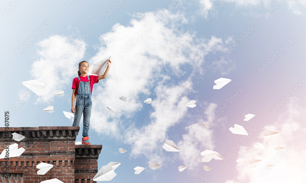 Concept of careless happy childhood with girl dreaming to become pilot Concept of careless happy childhood with girl dreaming to become pilot
