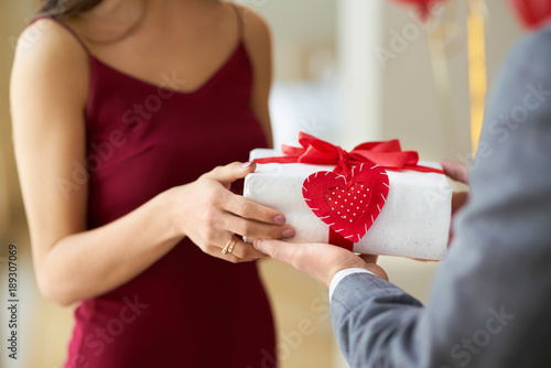 Valentine's Day concept. Happy couple in love with. A young loving couple celebrating Valentine's Day in the restaurant. Lovers give each other gifts. Romance restaurant for Valentine's Day- concep   © maxbelchenko