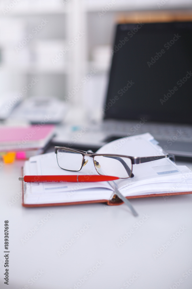 Office table with blank notepad and laptop Office table with blank notepad and laptop