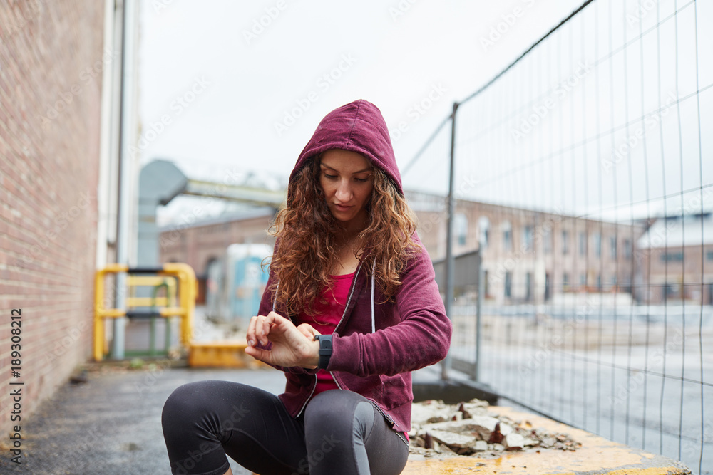 Junge Frau blickt auf ihren Fitness Tracker Junge Frau blickt auf ihren Fitness Tracker