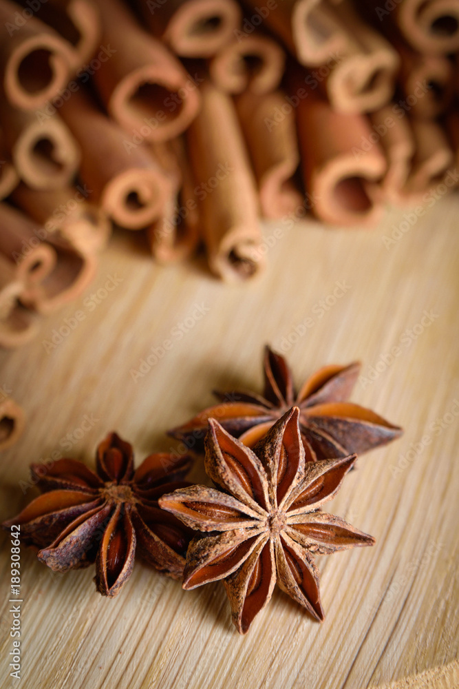shelves of cinnamon and anise stars in dark backgrounds on a wooden background shelves of cinnamon and anise stars in dark backgrounds on a wooden background
