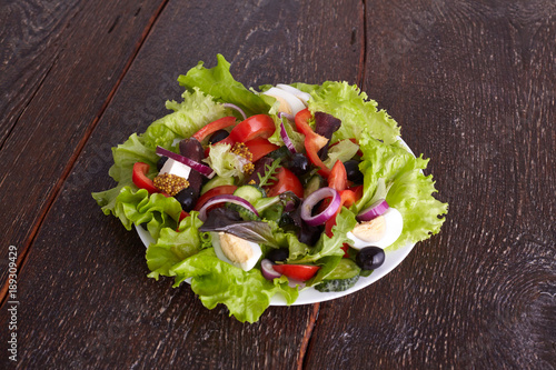 salad from fresh vegetables in a plate on a table, selective focus