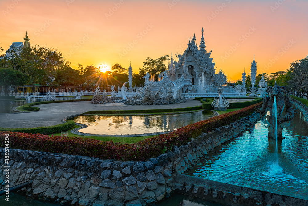 Wat Rong Khun(White temple)at sunset in Chiang Rai,Thailand.23/01/2018 Wat Rong Khun is modern building, well known worldwide.It was designed by Chalermchai Kositpipat.Opened it to visitors in 1997.