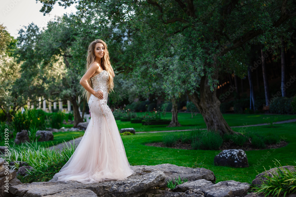 fashion outdoor photo of elegant beautiful woman with blond hair in luxurious sequins dress and silver accessories,posing in summer park fashion outdoor photo of elegant beautiful woman with blond hair in luxurious sequins dress and silver accessories,posing in summer park